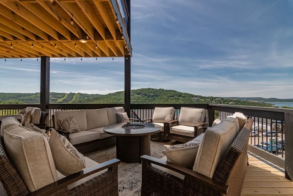 A cozy exterior seating area encircling a fire pit with sweeping views of the surrounding hills. The sunset glow adds warmth as guests gather to socialize and unwind under the open sky.