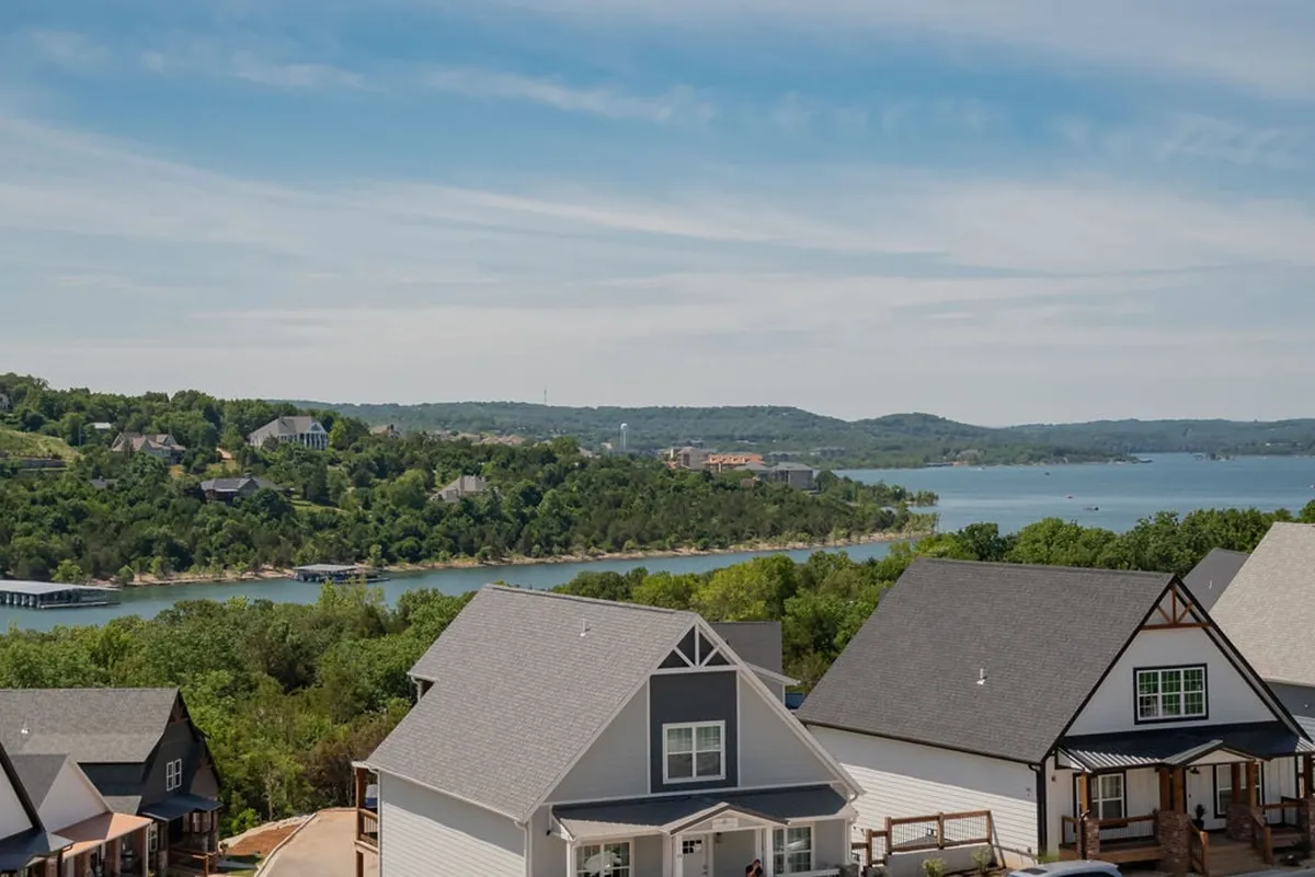 A sweeping view of the lake, lush hills, and the rooftops of nearby houses—an ideal setting for boating, hiking, and gathering with loved ones. The landscape invites exploration and adventure in the natural surroundings just minutes from the home.